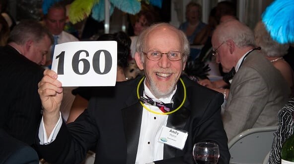 Smiling supporter of Cape Cod Village with auction card