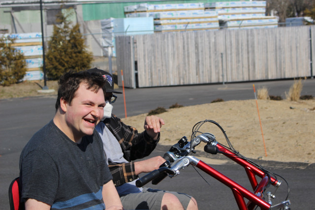 Man on three wheeled bike, smiling