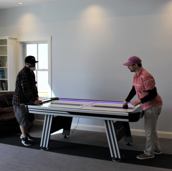 Two men playing air hockey at Cape Cod Village