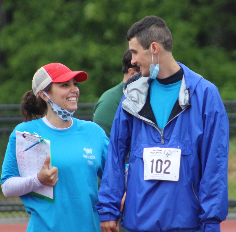 Two people smiling at one another at the Special Olympics